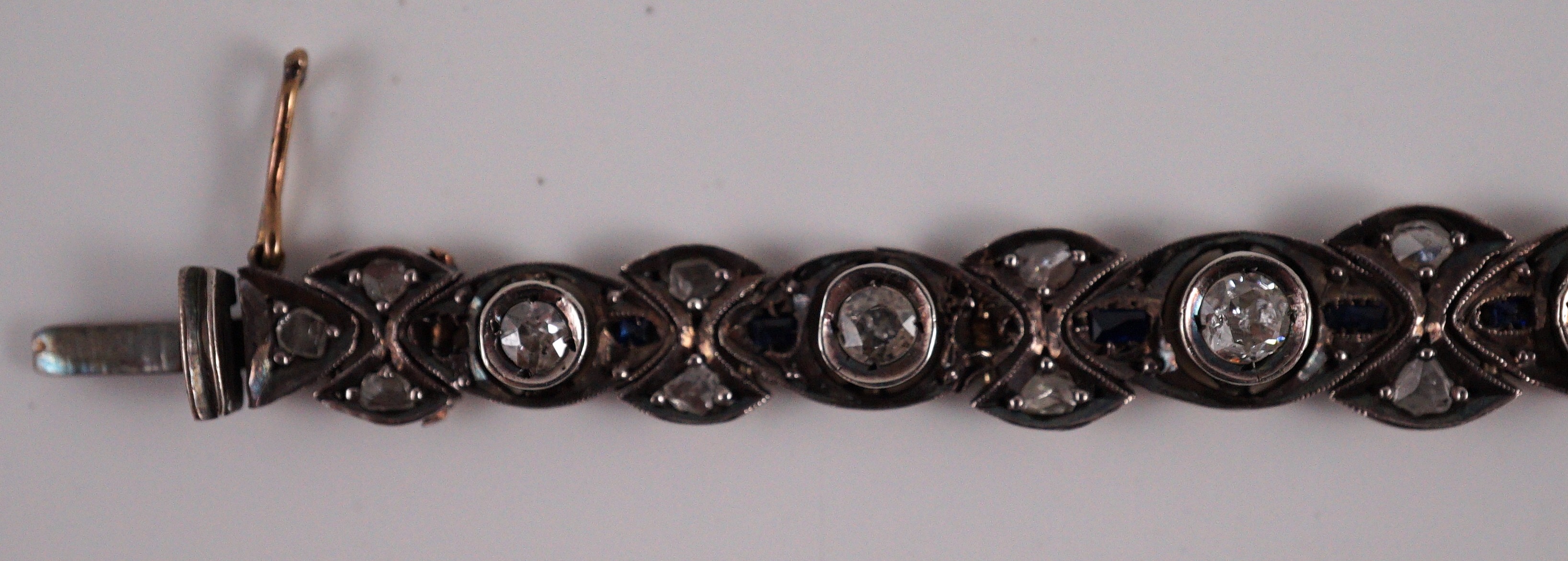 An early to mid 20th century continental gold and silver, graduated diamond and sapphire set line bracelet